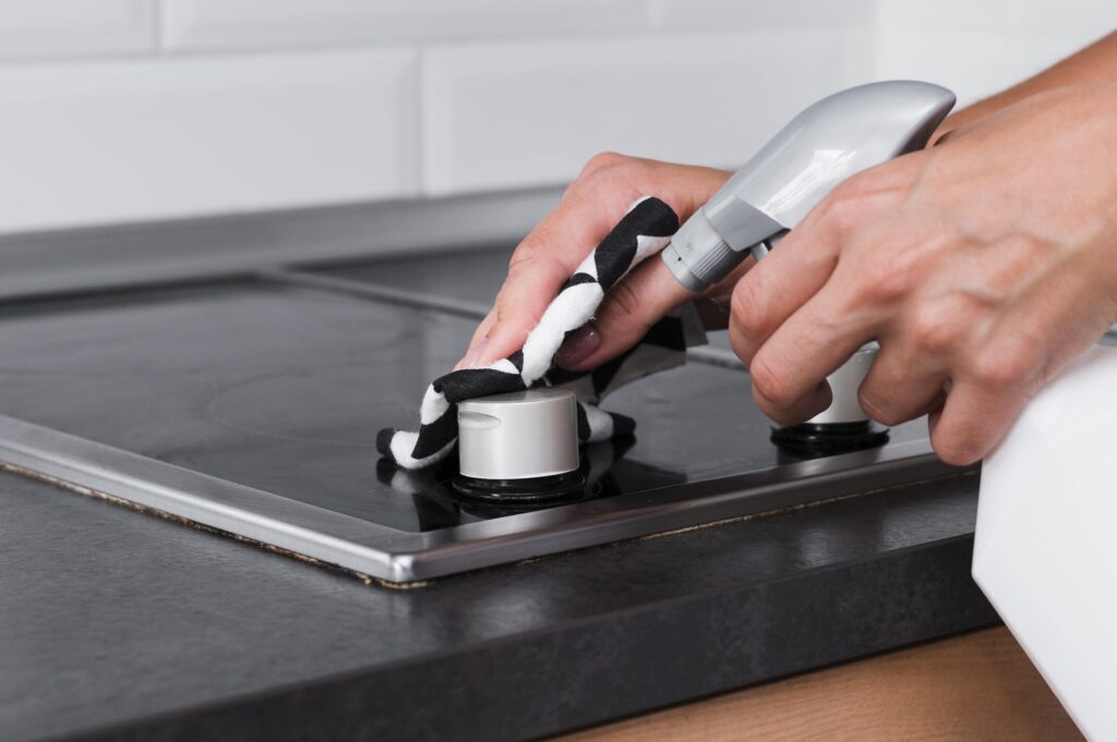 hands-disinfecting-stove-surface-min